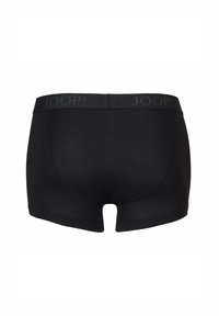 Black boxer shorts made of smooth fabric. Features a solid color with a logo-emblazoned waistband. Short leg design with a fitted shape.