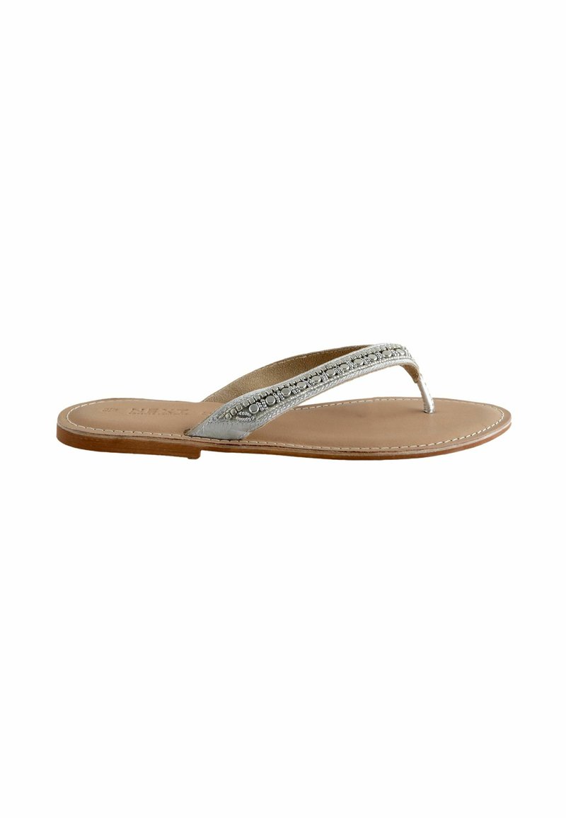 Silberne Flip-Flop-Sandale mit einem strukturierten Riemen und hellbraunem Fußbett. Die Sohle weist entlang der Kanten eine Naht auf, die für Langlebigkeit sorgt.