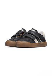 Scarpe di pelle nera con due cinturini in velcro, suola in gomma resistente e design a strisce zigzag bianche sul lato. Punta arrotondata con fodera morbida.
