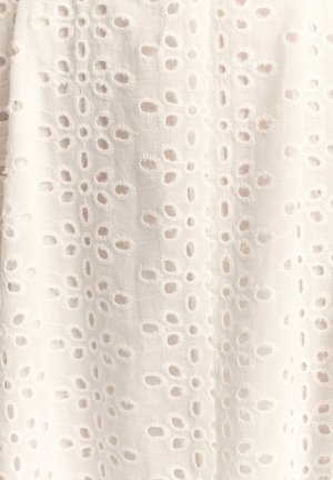 Balts audums ar teksturētu rakstu, kurā vienmērīgi izvietotas ovālas caurumi ar izšūtiem kontūrām, radot smalku izskatu.