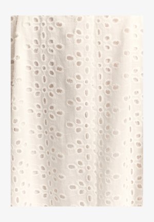 Valge kangas tekstuurse mustriga, millel on ühtlaselt paigutatud ovaalsed lõiked, mida ääristavad tikitud õmblused, luues õrna välimuse.