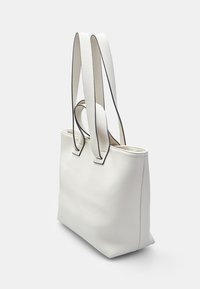 Hvid tekstureret tote bag med forlængede dobbelthåndtag og kontrastsort trim, der har et enkelt, struktureret design og åben top.