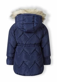 Manteau matelassé bleu marine avec capuche doublée en fausse fourrure, motif en losanges, taille élastique et poignets élastiques. Vue de dos montrée.
