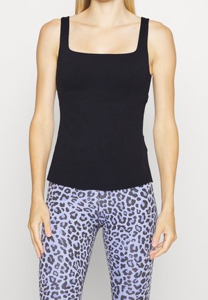 Black tank top with a square neckline and thick straps, fitted design, soft texture. Paired with purple leopard print leggings.