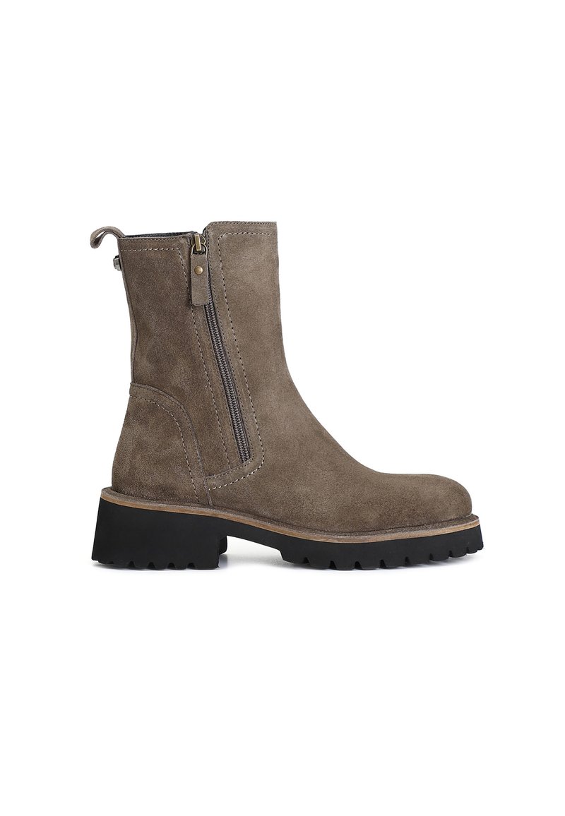 Botines de ante marrón con cremallera lateral, puntera redondeada, superficie texturizada y suela de goma negra gruesa con detalles de relieve.