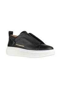 Sneakers slip-on in pelle nera con suola in gomma bianca. Presentano una finitura liscia, un design a strati e un marchio dorato sul lato.