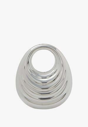 Ezüst díszítő tárgy sima, lekerekített formával és koncentrikus barázdákkal, amelyek egy központi kör alakú nyílásba vezetnek. Muffin fényes fémes felület.