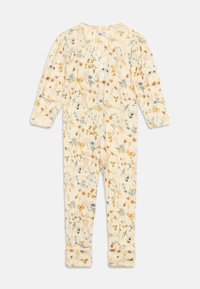 Kremfarget baby romper med lange ermer, prydet med flerfarget blomstermønster og foldbare mansjetter på bena, liggende flatt på hvit bakgrunn.
