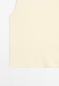 Canotta senza maniche di cotone color crema con scollatura rotonda e superficie liscia su uno sfondo bianco.