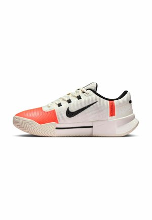 Scarpa sportiva bianca con swoosh Nike nero, punta arancione e tallone arancione, con suola strutturata e tomaia in tessuto a rete.
