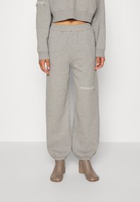 Grå mjukisbyxor med resårmidja och manschetter, med sidofickor och en minimalistisk design. Tillverkade av mjukt, texturerat tyg.