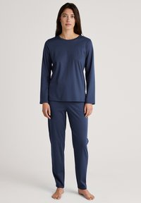 Navy blue long-sleeve top and matching pants made of smooth fabric, featuring a round neckline and fitted design without patterns or embellishments.