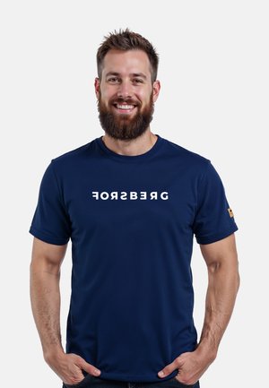 Camiseta de cuello redondo azul marino hecha de una tela suave, con la palabra "FORSBERG" en letras blancas en negrita en el pecho. Pequeño logo en la manga.