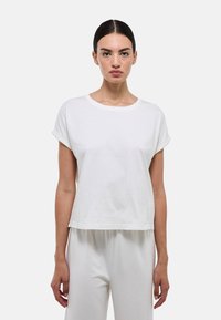 T-shirt blanc à manches courtes avec ourlets roulés, encolure ronde et coupe décontractée. Fabriqué en coton doux avec une texture lisse.