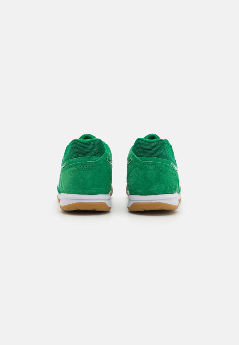 Zapatillas de ante verde con parte superior de malla, mediopie blanco y suela de goma natural. Características de un cuello y talón acolchados para mayor comodidad.