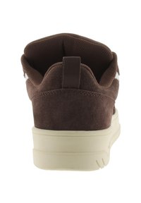 Sneaker in camoscio marrone con linguetta in rete, suola color crema e tab per il tallone a gancio. Presenta accenti bianchi minimali sui lati.