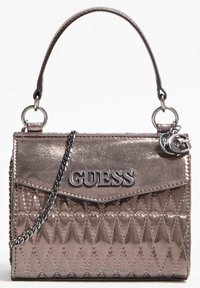 Sac à main en métal couleur rose gold avec texture matelassée, quincaillerie argentée et bandoulière en chaîne détachable. Présente le logo "GUESS" à l'avant.