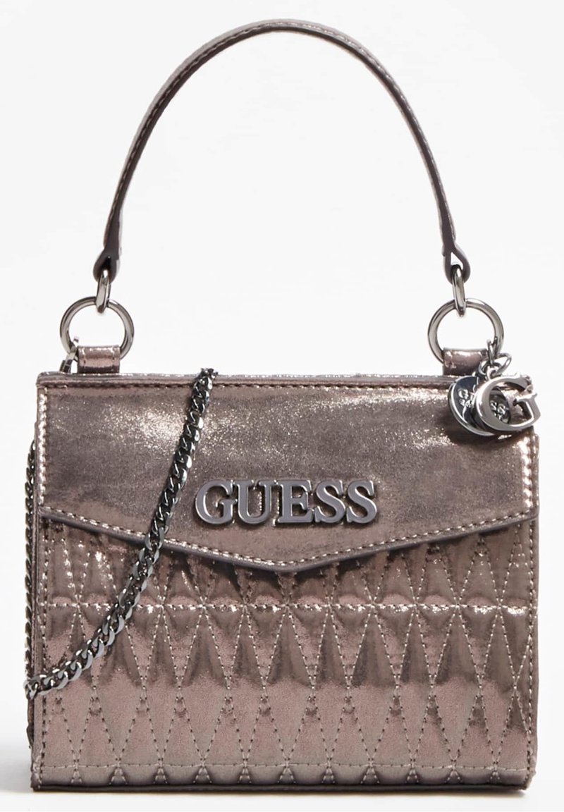 Sac à main en métal couleur rose gold avec texture matelassée, quincaillerie argentée et bandoulière en chaîne détachable. Présente le logo "GUESS" à l'avant.