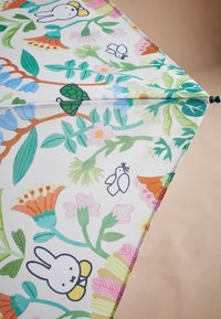 Vihmavari erksavärvilise lille- ja loomamustriga, millel on rohelised, roosad ja sinised toonid heledal taustal ning tugev konstruktsioon.