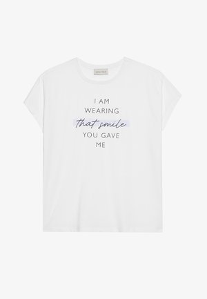 Valge lühikeste varrukatega T-särk, mis on valmistatud pehmest puuvillast, musta typograafia ja sinise esiletõstetud fraasiga, luues juhusliku graafilise disaini.