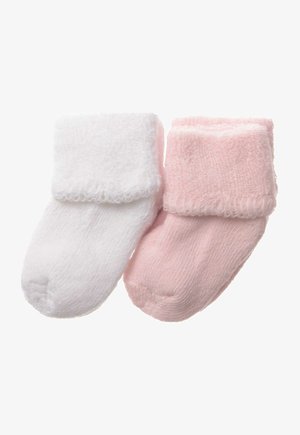 Ein Paar weiche Babysocken: eine weiße und eine hellrosa, beide mit umgeschlagenem Bündchen und strukturiertem Strickstoff.
