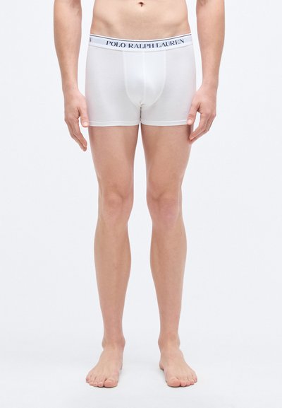 Valged puuvillased bokserpüksid tumesinise elastse vöökohaga, millel on kiri "POLO RALPH LAUREN". Sile tekstuur, keha järgnev lõige, keskmise reie pikkus.