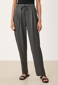Grijze geplooide broek met een trekkoord in de taille, gemaakt van een lichtgewicht stof. Kenmerkt zich door een relaxte pasvorm en een gladde textuur. Draag met zwarte sandalen.