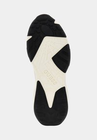 Zool van een sneaker met een zwarte rubberen buitenzool met gestructureerde grip, crèmekleurige tussenzool en een reliëf merklogo. Geometrisch patroon zichtbaar.