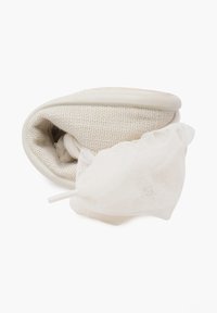 Beige slip-on shoe with a mesh lining, partially folded with a loose, white mesh bag attached, placed on a white background.