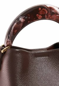 Sac à main en cuir marron avec une finition texturée et une anse en résine marbrée et brillante. Présente des accents en matériel doré.