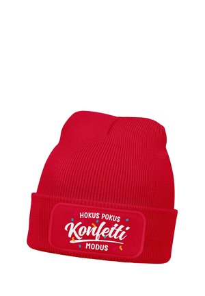 Red knitted beanie with folded cuff featuring white text "Hokus Pokus Konfetti Modus" surrounded by colorful confetti graphics.
