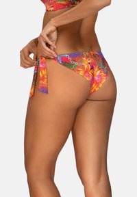 Kolorowe spodnie od bikini z kwiatowym wzorem, z wiązaniami po bokach i niskim stanem. Wykonane z gładkiej tkaniny.