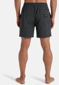 Costumi da bagno da uomo grigio scuro con cintura elastica, tasche laterali e una tasca posteriore con un patch del logo. Tessuto morbido con una texture liscia.