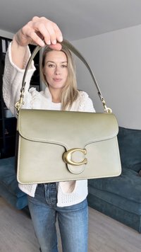 Ελιά πράσινη δερμάτινη τσάντα χεριού με δομημένο σχέδιο, διαθέτοντας κλείσιμο σε χρυσή απόχρωση και αποσπώμενο ιμάντα. Λείο υλικό, ελάχιστη ραφή.