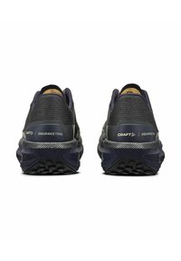Chaussures de trail running bleu foncé avec un tissu texturé, un talon renforcé et une semelle extérieure en caoutchouc à motifs. Marque "Craft" visible sur les côtés.