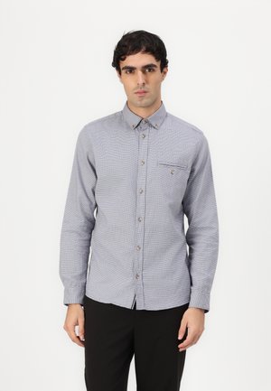 Camisa de botones en patrón a cuadros azul claro y blanco, de manga larga, con cuello, bolsillo frontal y botones marrones. Material de mezcla de algodón.