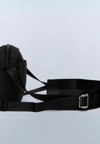Marsupio in nylon nero con chiusura a zip, cinturino regolabile in tessuto con fibbia metallica e logo impresso sul cinturino.