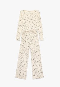 Långärmad pyjamasset i krämfärg med ett upprepande brunt mönster av små saxar. Toppen har en rundad halsringning och en knuten detalj vid midjan.