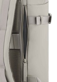 Zaino grigio con interno in tessuto testurizzato e tasca con zip. Presenta un esterno in nylon e spallacci regolabili per una chiusura sicura.