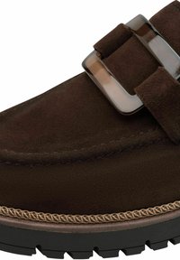 Brown suede slip-on shoe featuring a broad strap with a glossy buckle. Textured upper, stitched detailing, and a durable rubber sole.