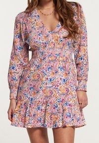 Vestido de manga larga y escote en V con cintura fruncida, que presenta un colorido patrón de paisley en rosa, naranja y azul, terminado con un dobladillo con volantes.