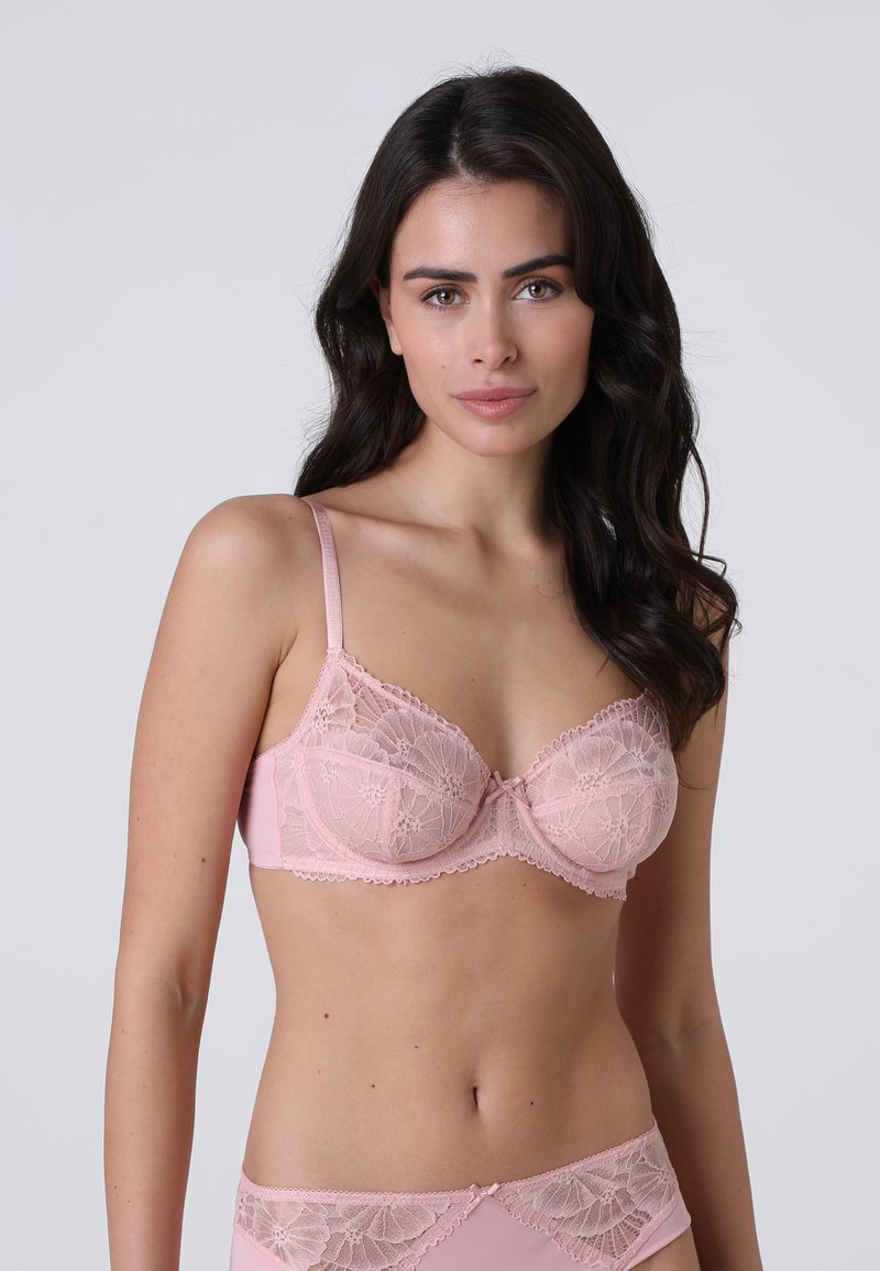 Reggiseno in pizzo rosa chiaro con motivi floreali, supporto con ferretto e spalline regolabili. Pannello posteriore liscio con dettagli in pizzo delicati.