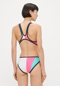 Swimsuit with a sporty design, featuring color-blocked panels in pink, teal, and white, trimmed with black. Racerback style enhances movement.