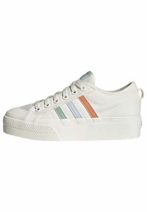 Biały niski sneaker z zapięciem na sznurówki, zielone, niebieskie i pomarańczowe boczne paski, grubą gumową podeszwą oraz teksturowanym czubkiem.