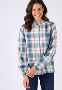 Camicia a quadri leggera con motivo a scacchi blu, verde e rosso, caratterizzata da un colletto rotondo e una chiusura con bottoni sul davanti, maniche lunghe con polsini arricciati.