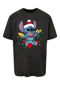 Camiseta de algodón negra con un gráfico de un personaje de dibujos animados que lleva un gorro de Santa, sosteniendo luces de Navidad coloridas, con un acabado desgastado.
