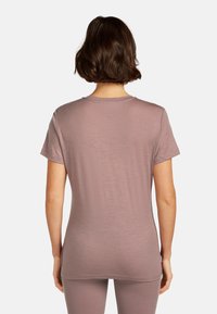 Kortærmet T-shirt med rund hals i blødt, mauve stof. Glat tekstur med minimale sømme, tætsiddende design og rund kant.