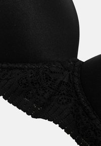 Schwarzer BH mit glatten, geformten Körbchen und breitem Spitzenband mit Blumenmustern und gezackten Kanten.