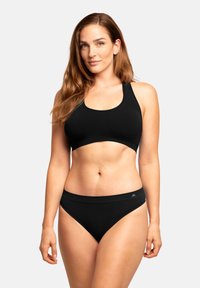 Bikini negro con un top de escote redondeado y braguitas de tiro bajo a juego. Fabricado con un material suave, con costuras mínimas y un detalle discreto del logo.