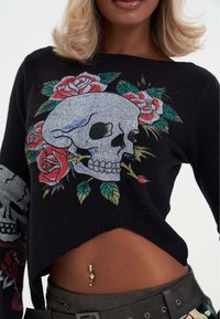 Maglione nero lavorato a maglia con un grande design di teschio e rose, colori intricati, silhouette corta e dettagli sfrangiati all'orlo.